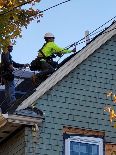 Roofer installing shingles on a residential roof