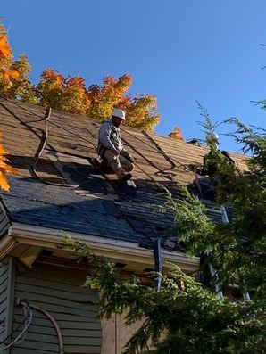 Contractor working on a roof in fall