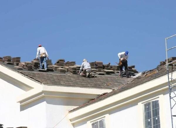 Roofing crew installing new shingles